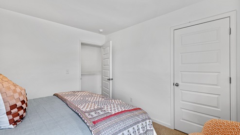 The primary bedroom has enough space for a king sized bed, two nighstands, a dresser, and a seating area.