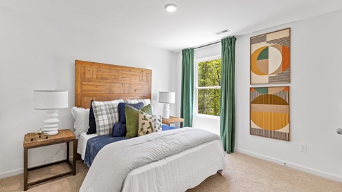 The primary bedroom has enough space for a king sized bed, two nighstands, a dresser, and a seating area.