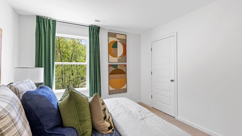 The primary bedroom has enough space for a king sized bed, two nighstands, a dresser, and a seating area.