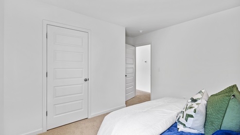 The primary bedroom has enough space for a king sized bed, two nighstands, a dresser, and a seating area.