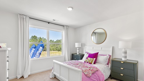 The primary bedroom has enough space for a king sized bed, two nighstands, a dresser, and a seating area.