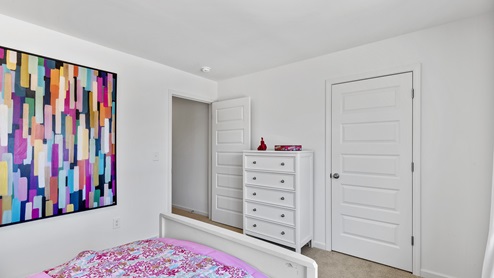 The primary bedroom has enough space for a king sized bed, two nighstands, a dresser, and a seating area.