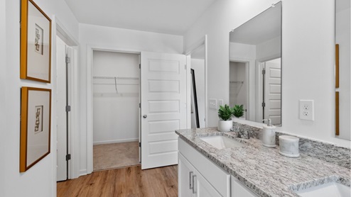 The main level features a spacious, full-sized bathroom equipped with a vanity, single sink, toilet, and a shower tub.