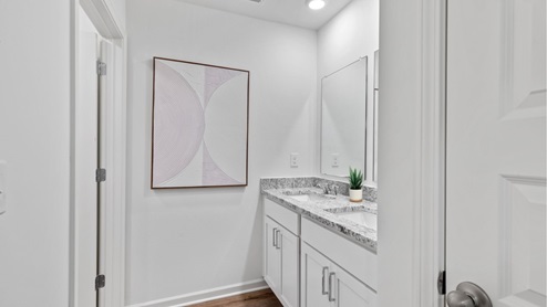 The main level features a spacious, full-sized bathroom equipped with a vanity, single sink, toilet, and a shower tub.
