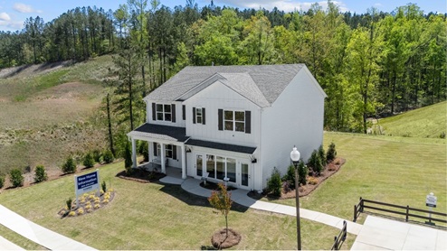 A white two story home surrounded by green grass and blue sky in Chelsea Alabama.