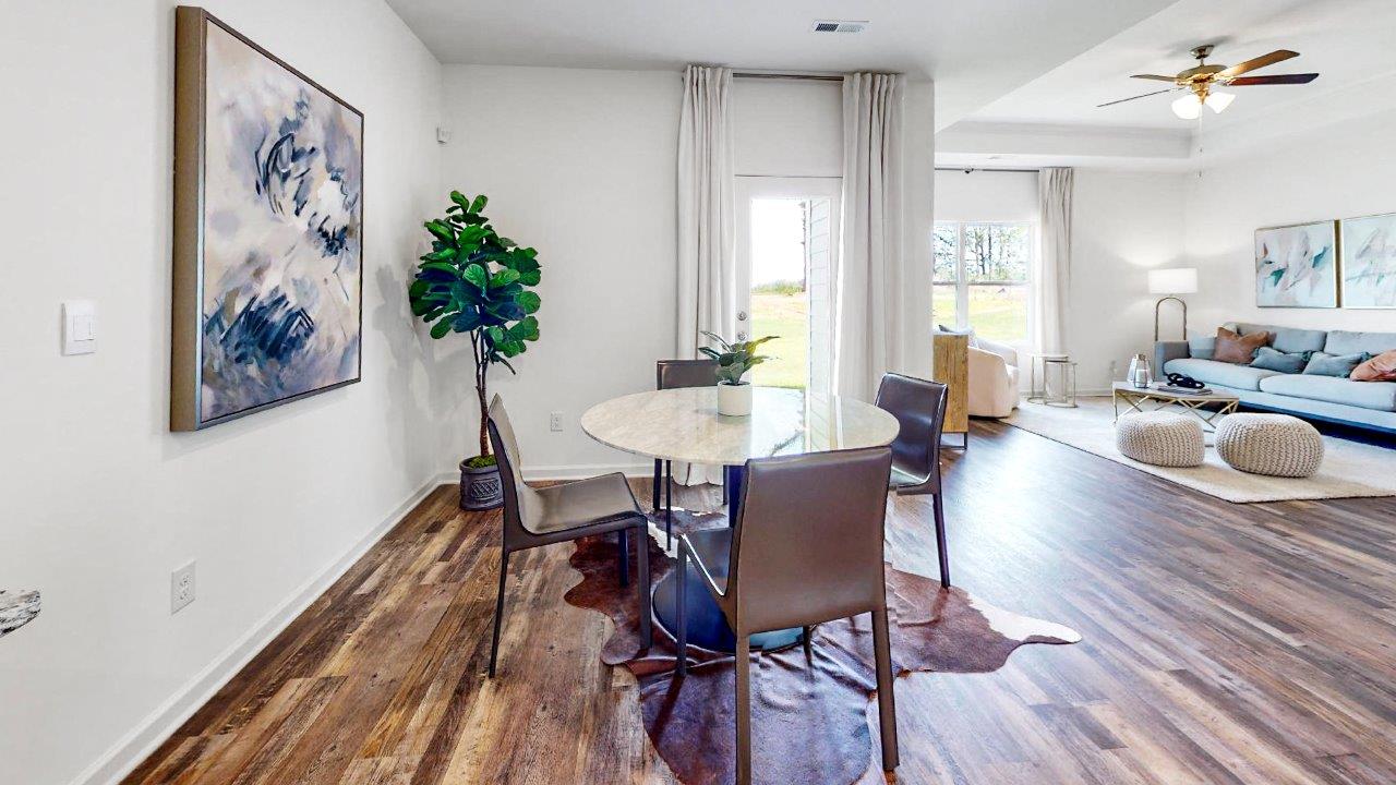 Rhett – Dining Room – the dining room is right off the kitchen and living room that shows a circular table with 4 chairs and the door to the covered patio