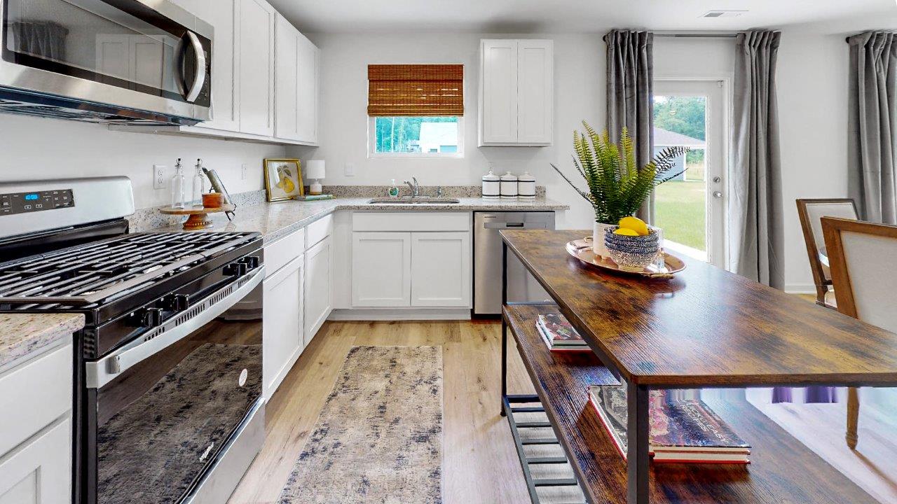 Taylor – Kitchen – 2 – A kitchen with sleek white cabinets, modern stainless steel appliances, and a wooden kitchen shelf