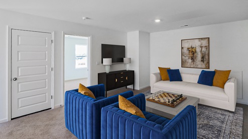 A spacious empty room featuring soft carpet flooring and clean white walls, creating a bright and airy atmosphere.