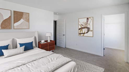 A spacious empty room featuring soft carpet flooring and clean white walls, creating a bright and airy atmosphere.