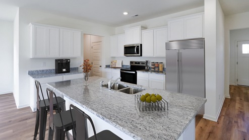 A stylish kitchen showcasing granite counter tops, white cabinetry paired with stainless steel appliances, emphasizing a clean and modern design.
