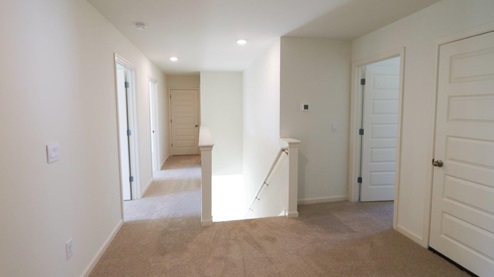 Bright and inviting hallway featuring modern interior design and soft carpet, perfect for any home.