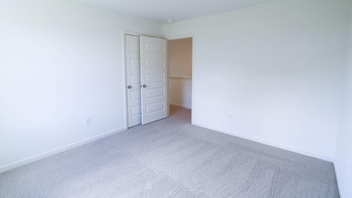 Bright and spacious room with fresh carpet and clean white walls, perfect for creating a cozy living space.