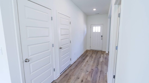 Bright and inviting hallway showcasing modern design with natural light and stylish doors.