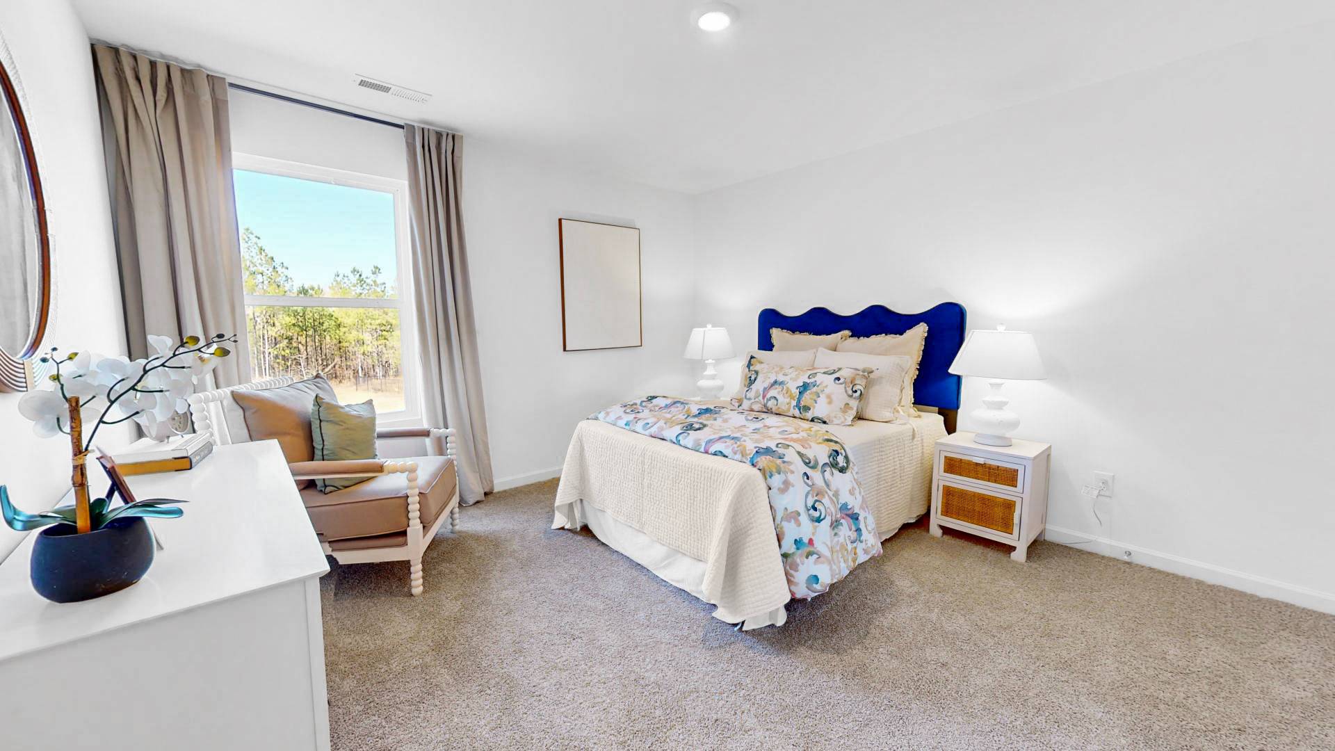 Spacious second bedroom with a bed, 2 nightstands, and chair and a dresser