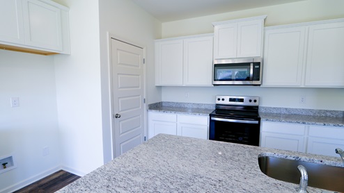 Bright and modern kitchen space with ample natural light, perfect for family gatherings and everyday cooking. The kitchen space is designed to be bright and modern, with plenty of natural light flooding in. It is an ideal setting for family gatherings as well as everyday cooking.