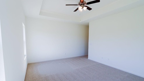 Bright and spacious bedroom featuring large windows and a ceiling fan for optimal comfort. The bedroom is well-lit and has ample space, with large windows that let in plenty of natural light. It includes a ceiling fan to ensure optimal comfort and air circulation.