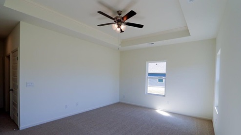 Bright and spacious bedroom featuring large windows and a ceiling fan for optimal comfort. The bedroom is well-lit and has ample space, with large windows that let in plenty of natural light. It includes a ceiling fan to ensure optimal comfort and air circulation.