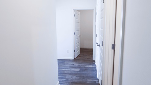 Bright and airy hallway showcasing stylish doors and sleek flooring design. The hallway is designed to be bright and airy, with stylish doors and sleek flooring that create an inviting atmosphere.