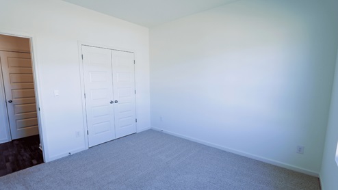Bright and spacious empty room with fresh carpet, ideal for any home decor project. This room is bright and spacious, offering a great canvas for any home decor project. The fresh carpet adds to the inviting atmosphere and provides a comfortable foundation for your design ideas.