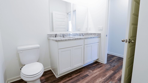 Modern bathroom featuring a stylish double vanity with granite countertops and fresh finishes. This modern bathroom showcases a stylish double vanity with elegant granite countertops. The fresh finishes in the bathroom add a contemporary touch to the overall design.