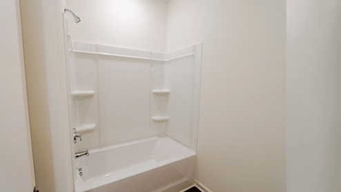 Modern bathroom with a clean tub and shower design, perfect for relaxing. This modern bathroom features a clean tub and shower design, which creates a perfect environment for relaxation.