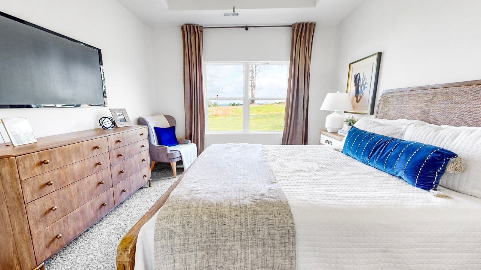 A stylish bedroom with a white bed dressed in a bright orange bedspread, offering a fresh and lively decor.