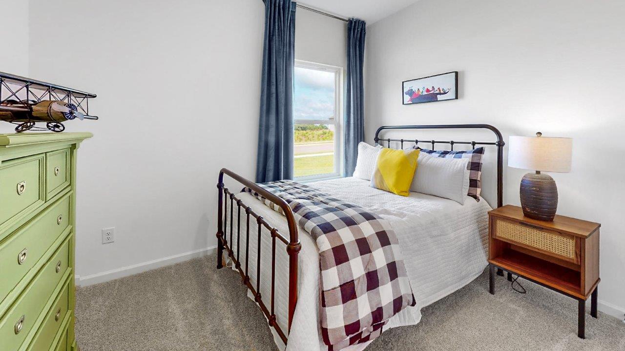 A fullsized bed with nightstand and dresser