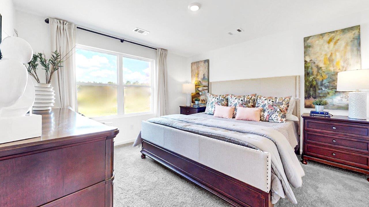 Large primary bedroom with an large king bed and double window