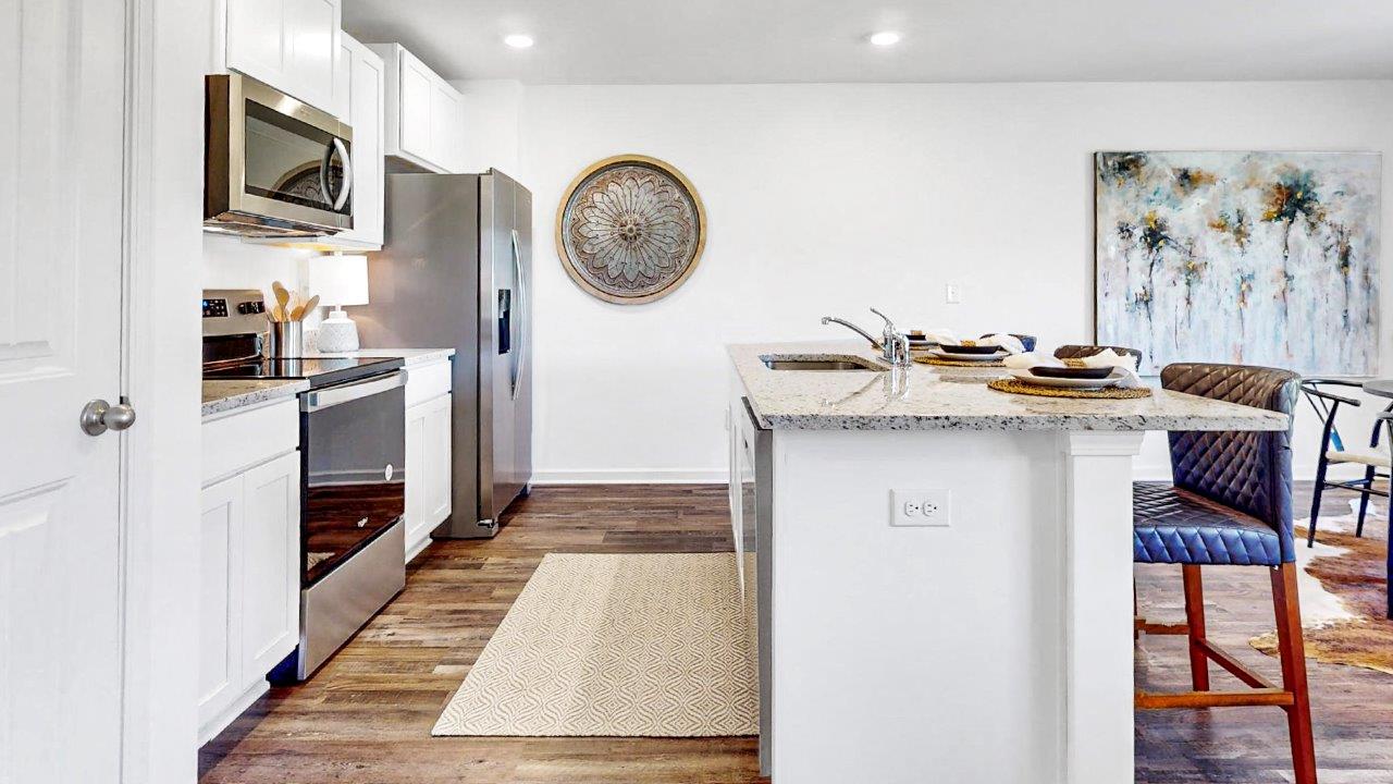 Chef inspired kitchen that features a pantry, stainless steel appliances, and a large kitchen island