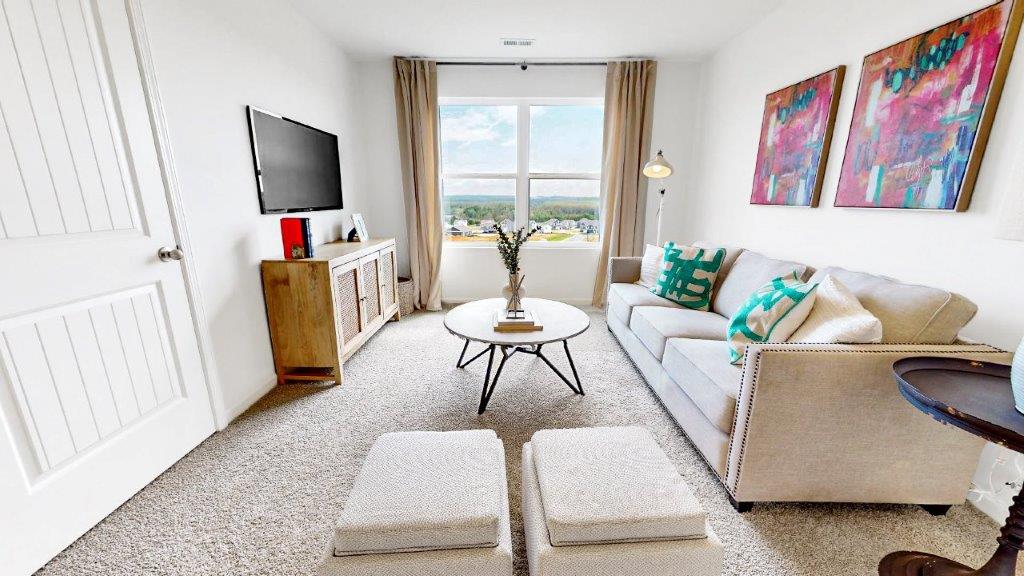 Loft style bonus room is great for entertaining or a play area for children with a couch and media consol