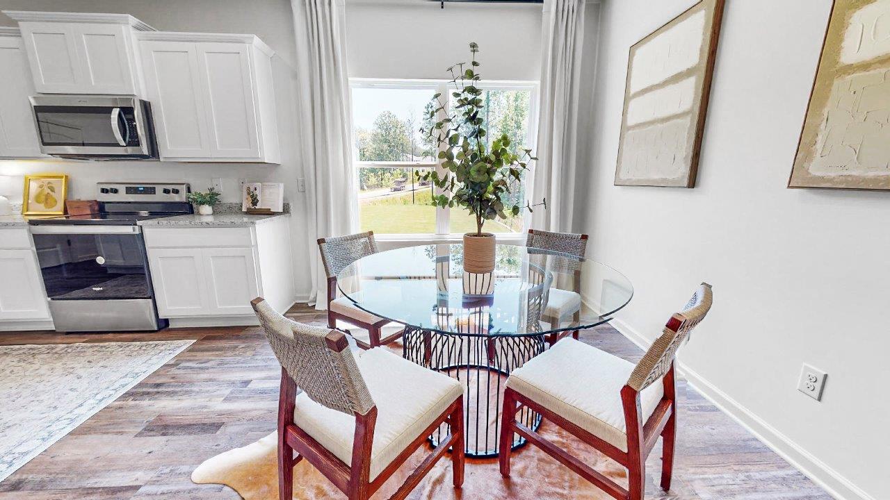 Breakfast nook which is right off the kitchen features a round glass table with four chairs