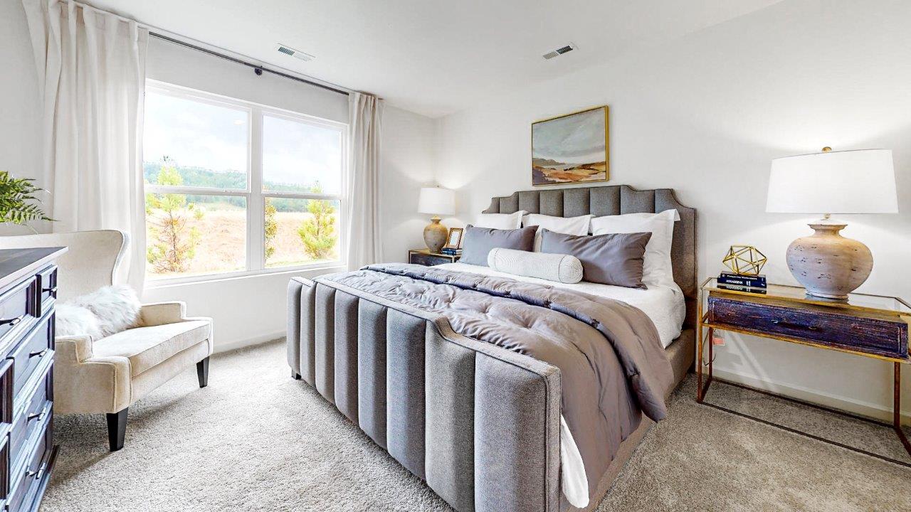 Large primary bedroom with an large king bed and double window