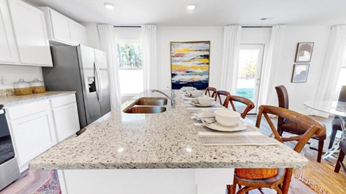 5.	Penwell – Kitchen – 2 – Kitchen featuring stainless steel appliances and a kitchen island with barstools.