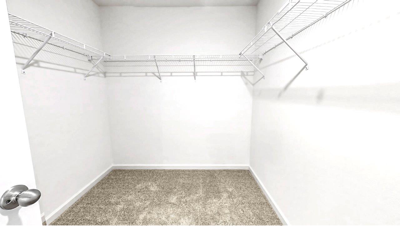 the primary bedroom walk in closet is located in the back of the bathroom with ample space for clothes