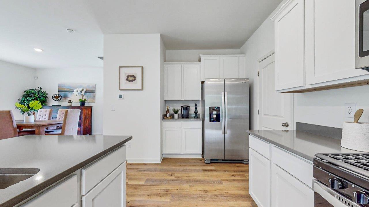 view of the kitchen that shows the stainless steel appliances, and the walk in pantry