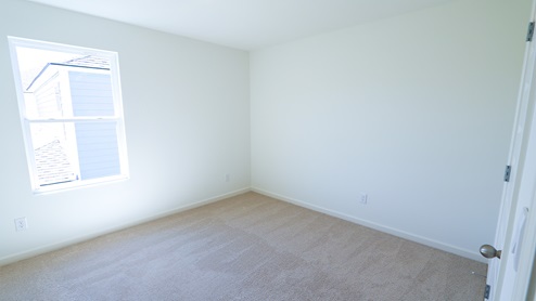The third bedroom features plush carpet and a spacious closet.