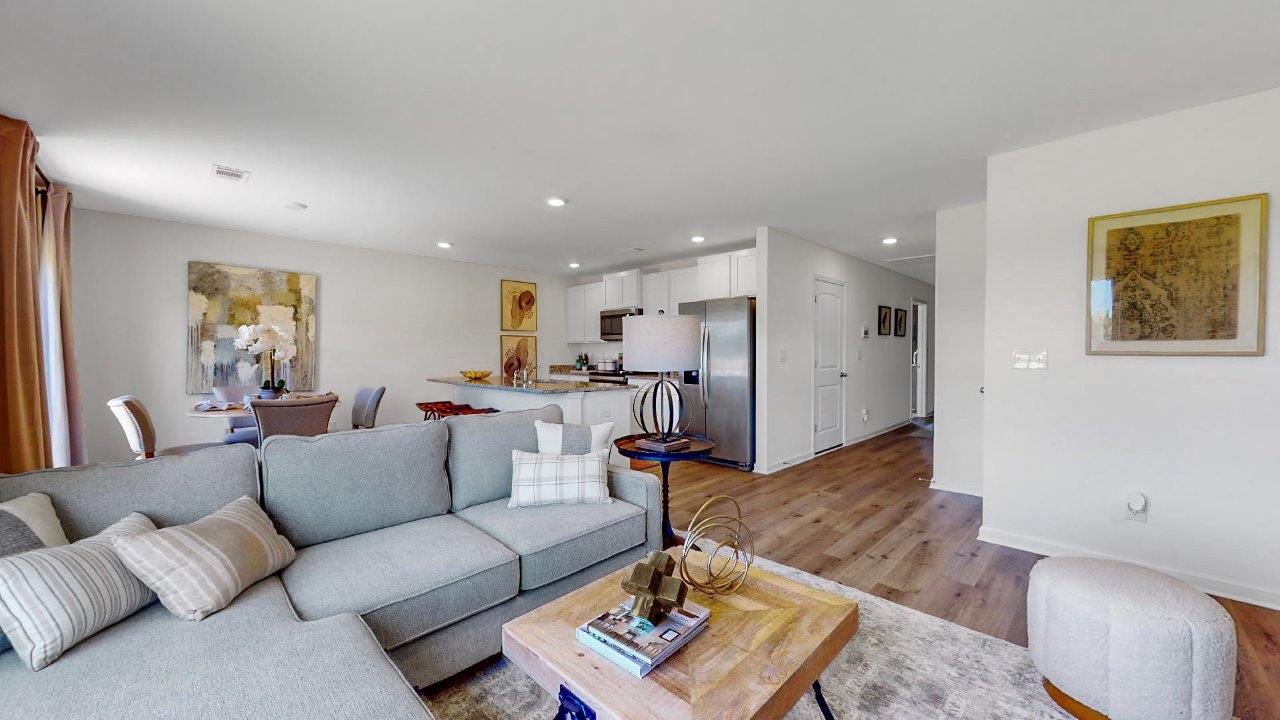 Different angle of the living room that shows the open flow to the dining area and kitchen