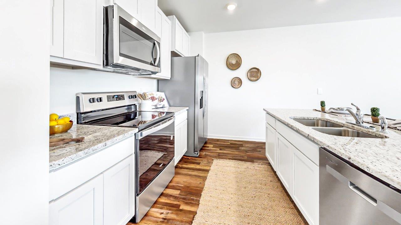 Different view of the kitchen shows the stainless steel appliances and oversized island