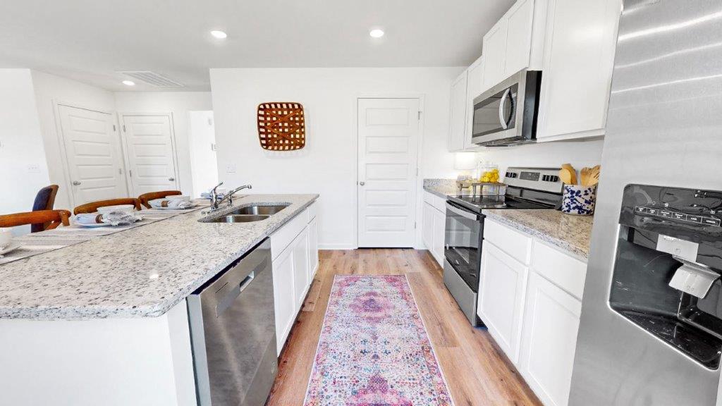 Kitchen with stainless steel appliances with a door to the walk-in pantry