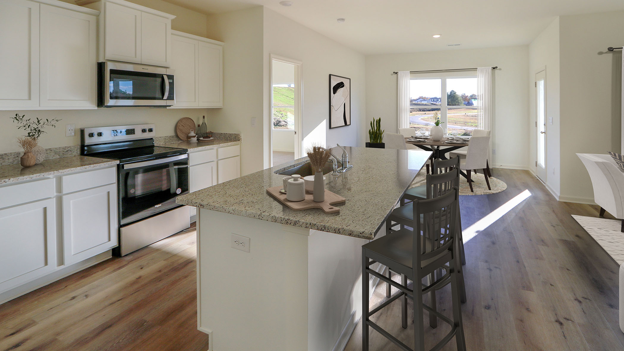 A spacious kitchen featuring a large island and a cozy dining area, designed for both cooking and entertaining.