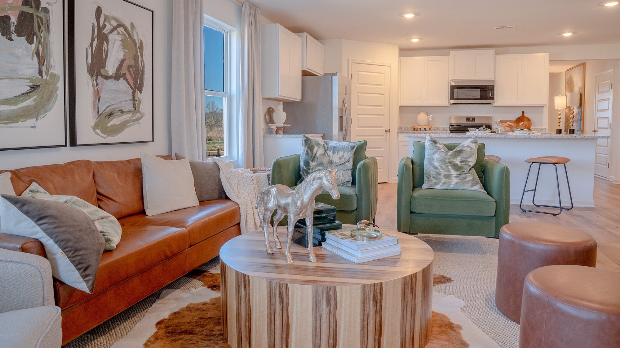 The living room features a large amount of light, owing to the windows and ample lighting throughout.