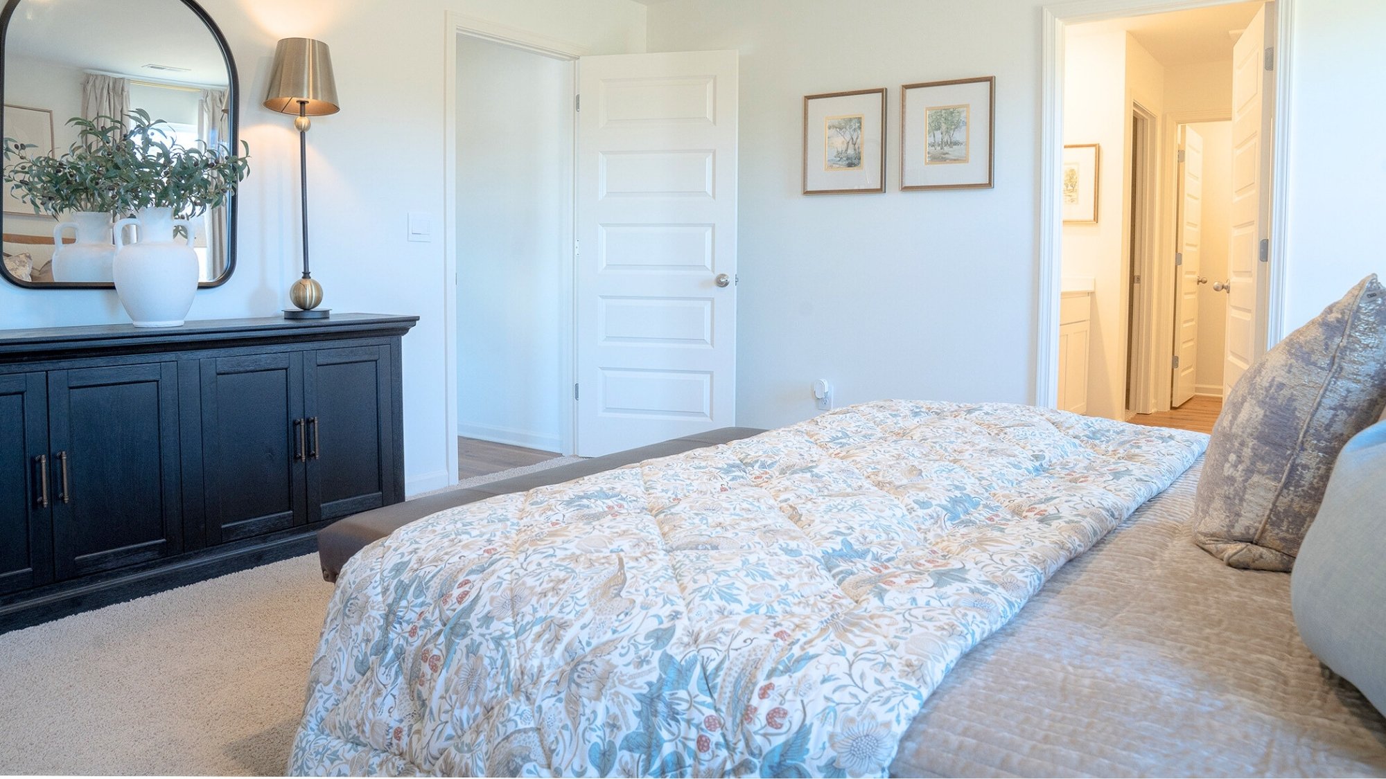 Primary bedroom with expansive windows, wood-finished floors, and a private, spa-like bathroom just off the main space.