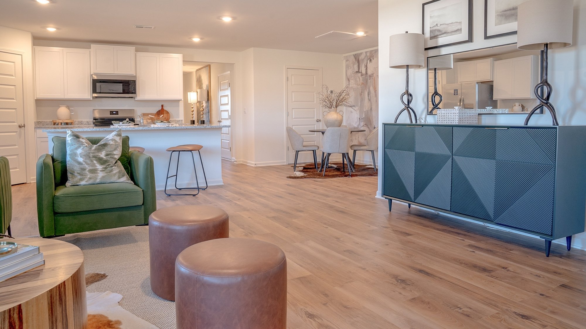 The living room features a large amount of light, owing to the windows and ample lighting throughout.