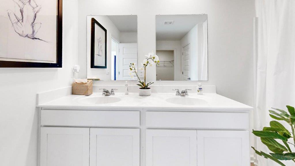 7. Cali – Kitchen – 2 – a different view of the kitchen that shows the white kitchen cabinets, as well as stainless steel appliances and the walk in pantry