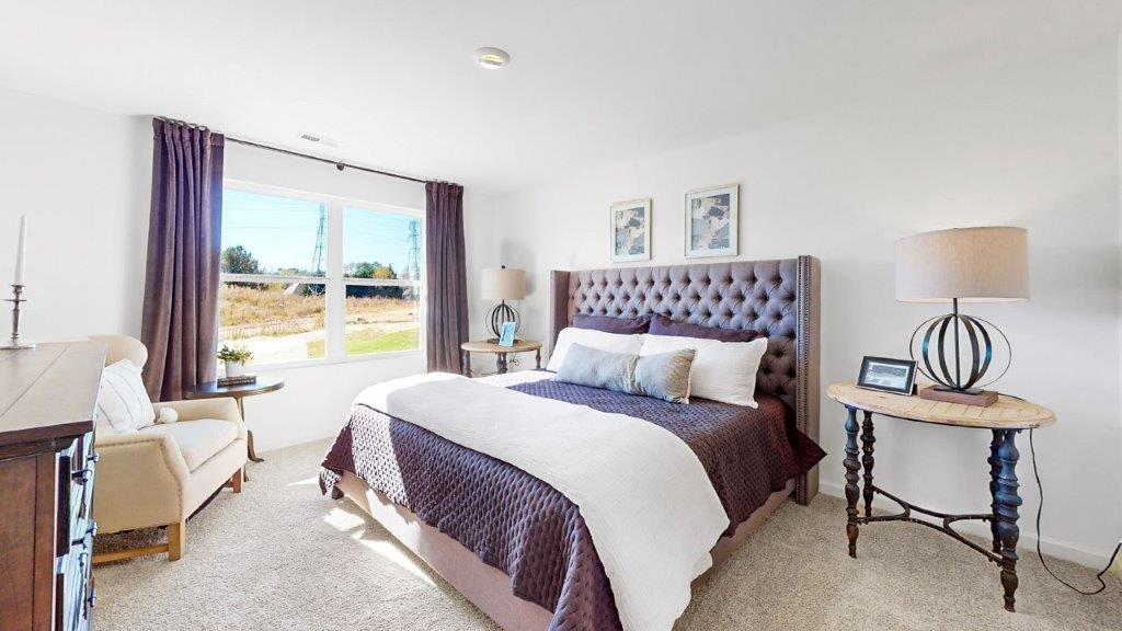 9. Cali –  Primary bedroom – 2- The bright primary bedroom fits a king sized bed, 2 nightstands, a dresser, and an accent chair