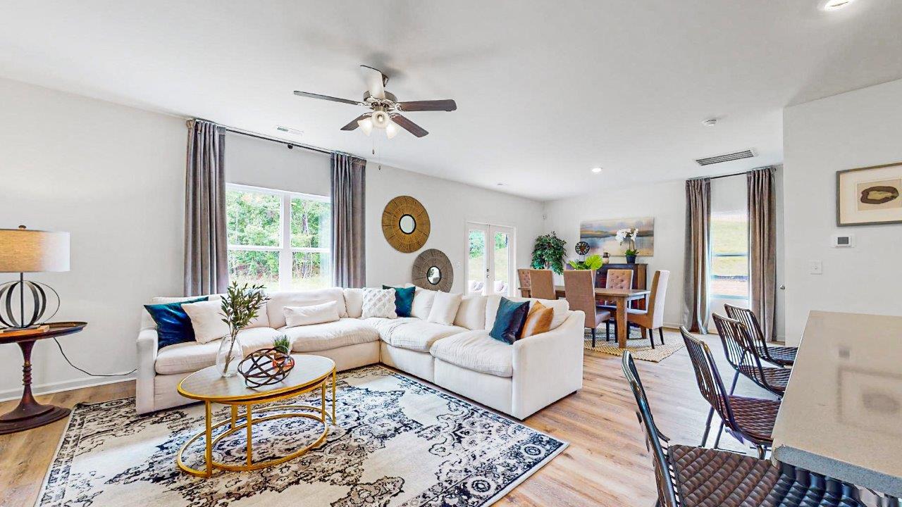 Elston – Living Room – 3 – Living room with secioual couch that opens to the breakfast nook as well as the kitchen