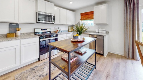 6. Taylor – Kitchen – 2 – A kitchen with sleek white cabinets, modern stainless steel appliances, and a wooden kitchen shelf