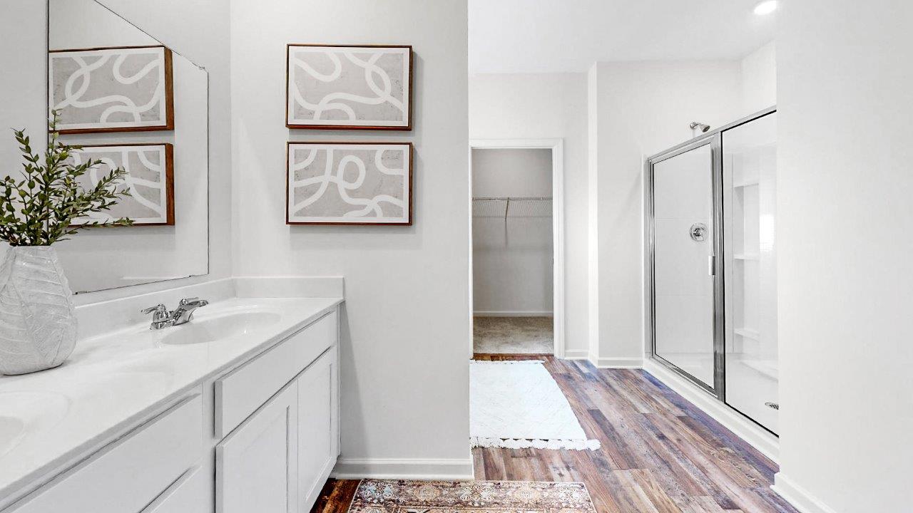 The primary bathroom features a spacious walk-in shower. Additionally, it includes a large soaking garden tub for relaxation. There is also a water closet for added privacy.