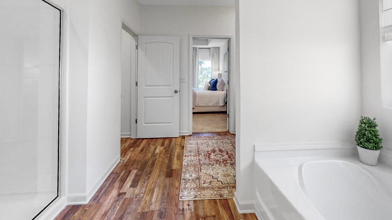 The primary bedroom closet is off the primary bathroom and shows a large walk-in closet with carpet and wire shelving.