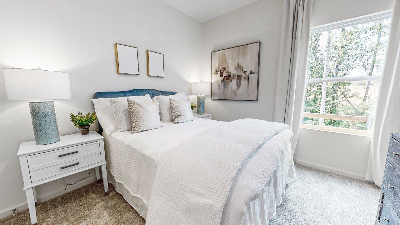 The second bedroom is furnished with a queen-sized bed and two nightstands.